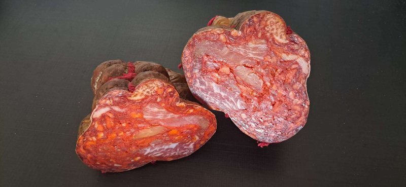 Morcón ibérico entero y en corte sobre fondo oscuro