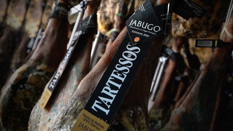 Jamones colgados con su vitola de identificación colocada sobre la pieza